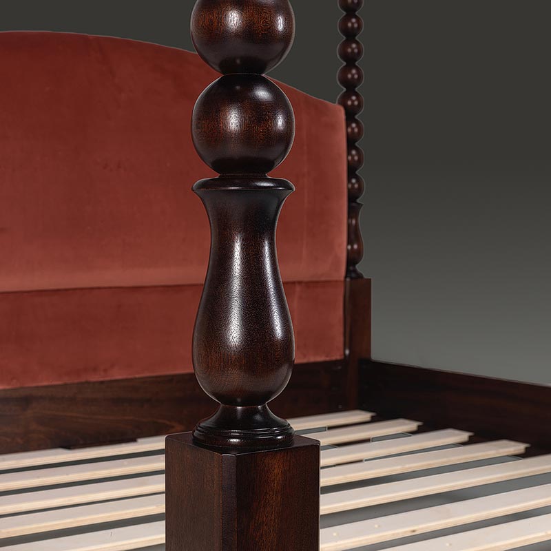 Close-up of turned bobbin post detail on dark stained oak four poster bed