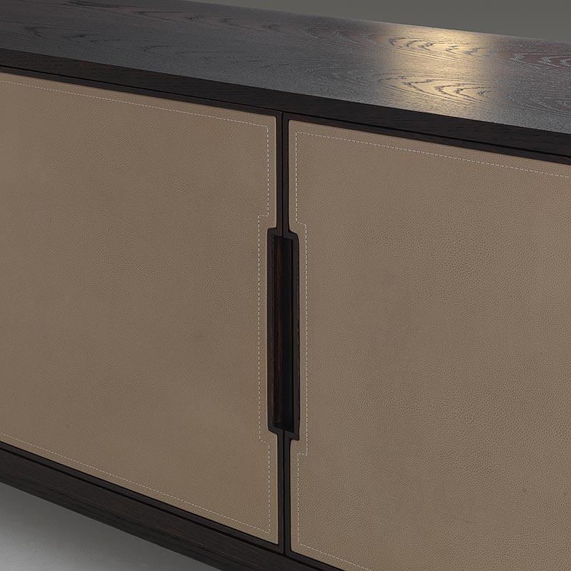 Close-up of leather-wrapped cabinet doors with inset handles on oak sideboard